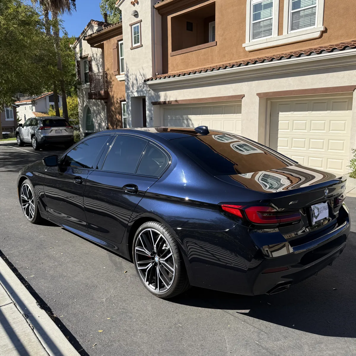 Rear three-quarter view of a BMW 5 Series with 20% side-window tint and 5% rear-window tint