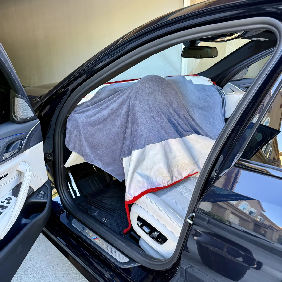 Protective towels covering the BMW 5 Series dashboard during windshield tint installation