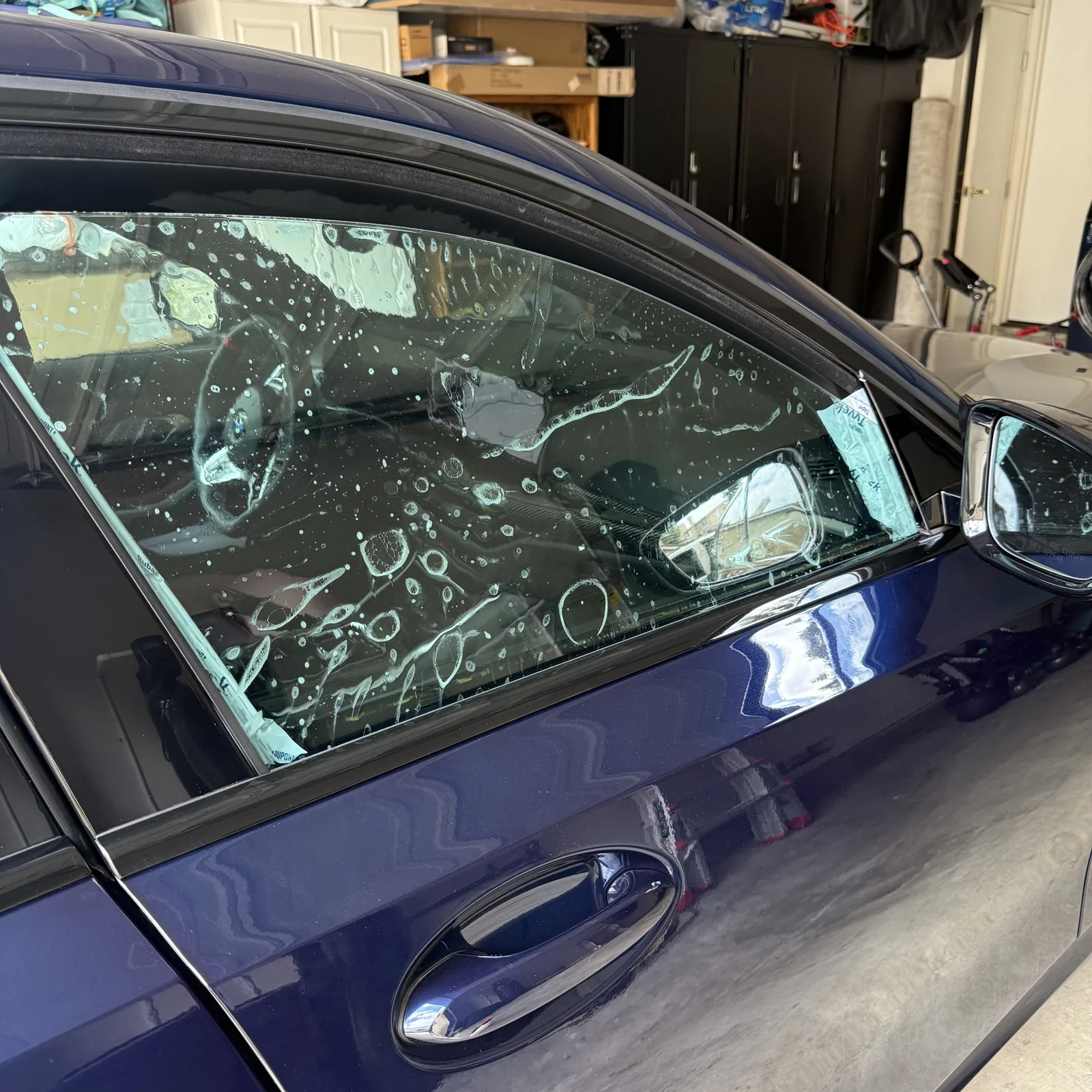 Nano Ceramic IR film being applied to a BMW front door window with application solution visible