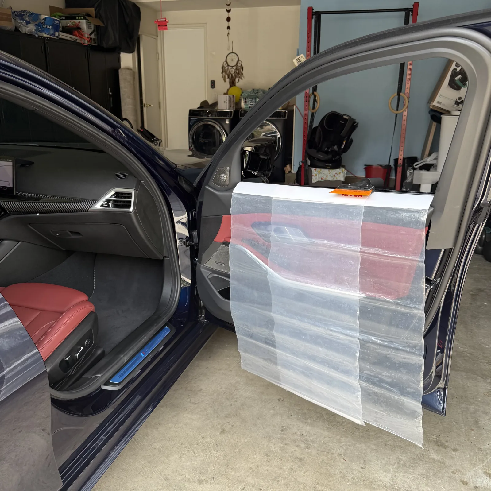 Protective sheeting covering BMW door panels during window tint installation