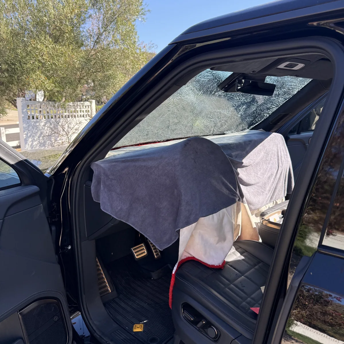 Dashboard protected with towels during Rivian R1S windshield tint installation in Poway