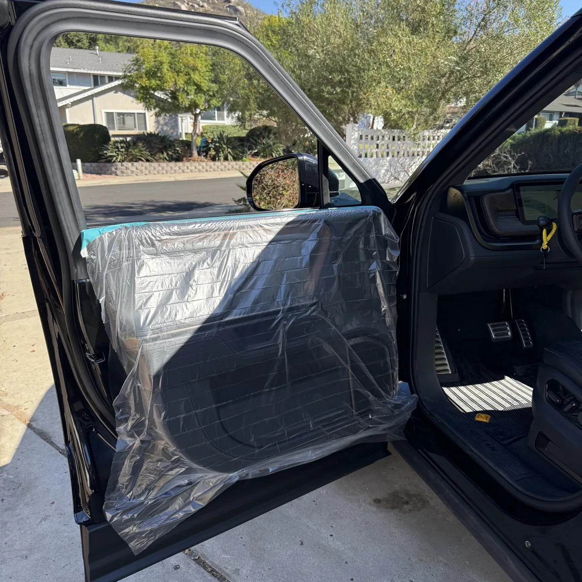 Rivian R1S door panels covered for protection during window tint installation in Poway