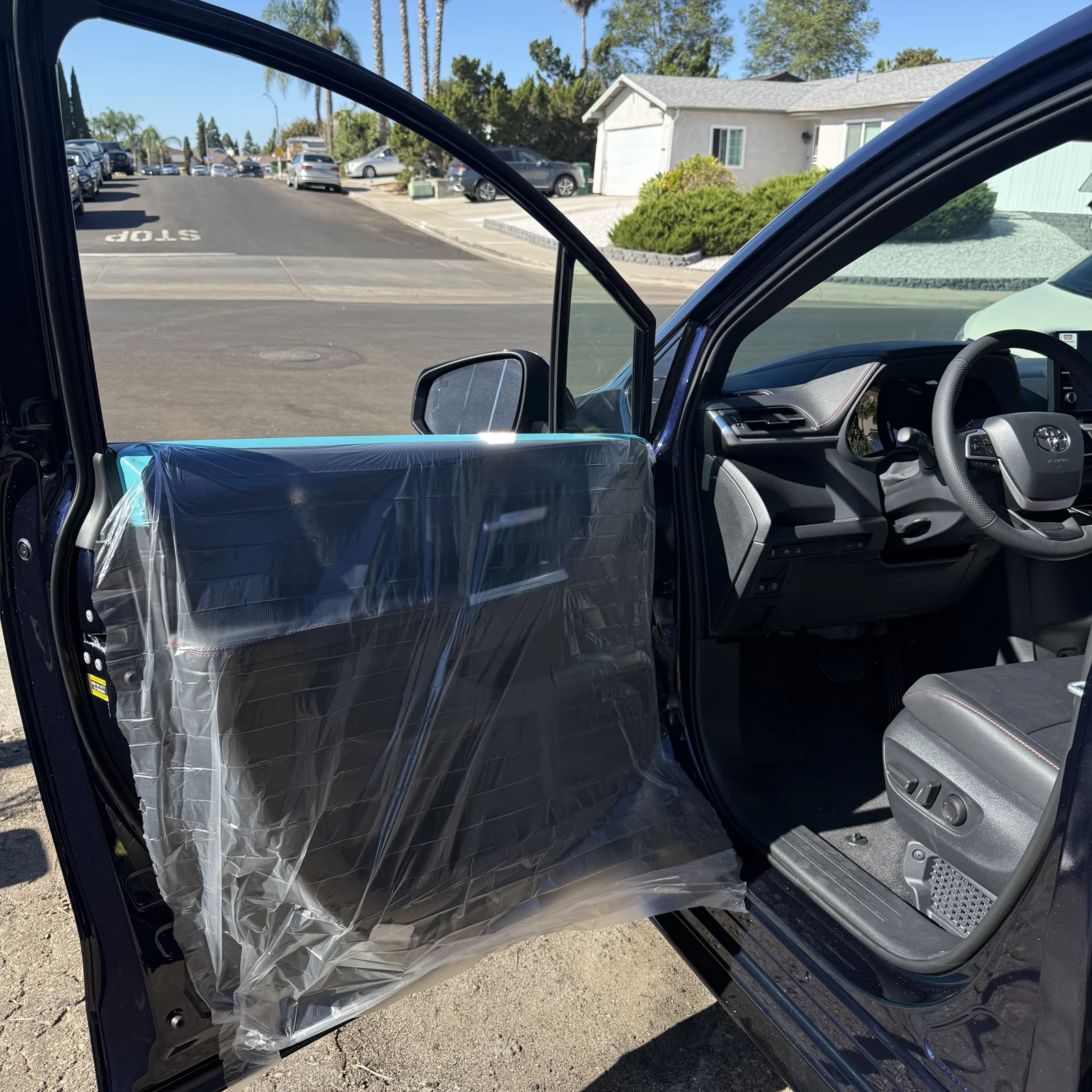 Protective sheeting over Toyota Sienna door panels during window tint installation